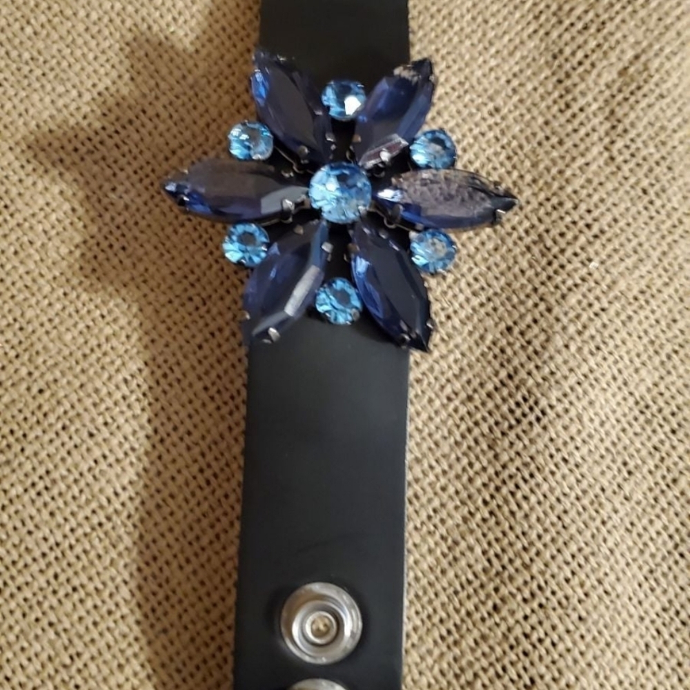 Leather cuff bracelet embellished with a vintage brooch.